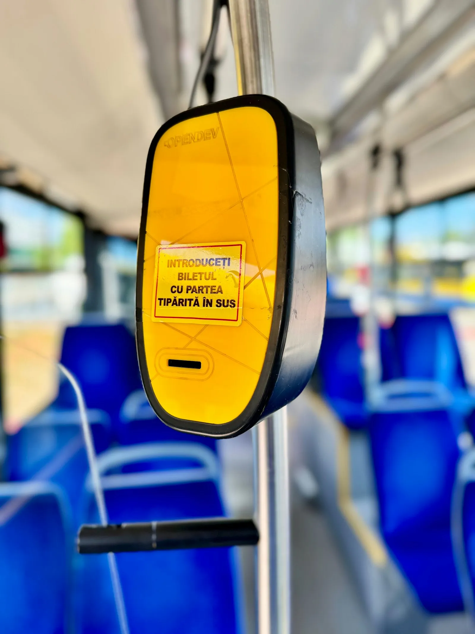 Compostor de bilete galben într-un autobuz